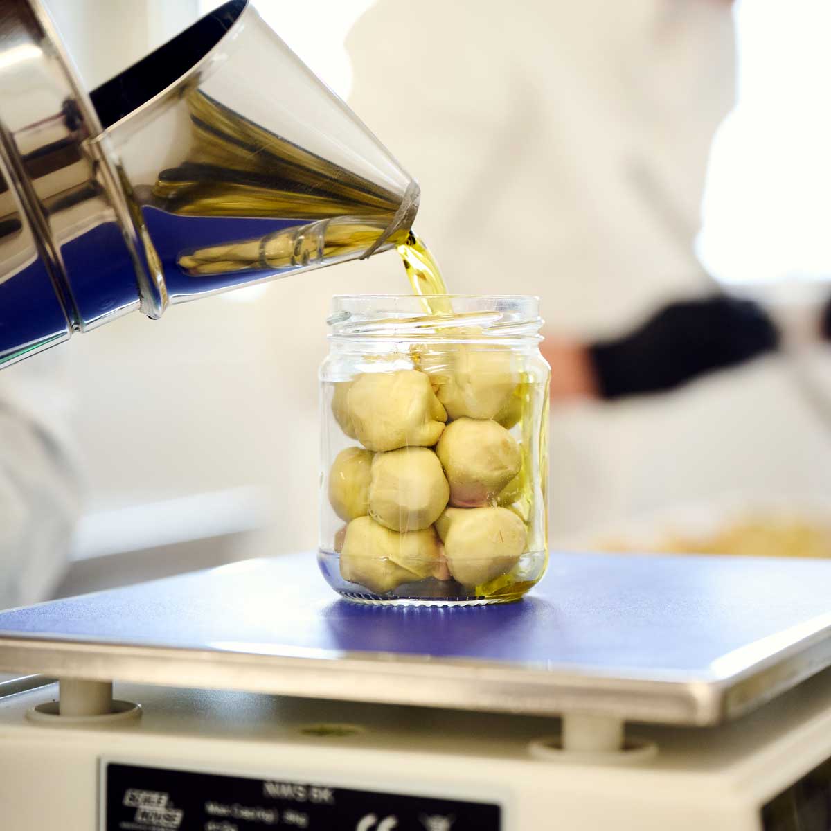 Italienischer Produktionsschritt Olivenöl einfüllen Artischocken Paestum Salerno Bio von Di Bennardo